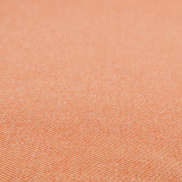 A vibrant apricot or orange textile with a tight diagonal twill weave. The fabric is woven with a primary saturated orange thread interspersed with fine white or cream yarns, creating a bright, textured surface with a subtle "salt and pepper" effect.