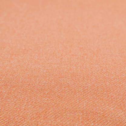 A vibrant apricot or orange textile with a tight diagonal twill weave. The fabric is woven with a primary saturated orange thread interspersed with fine white or cream yarns, creating a bright, textured surface with a subtle "salt and pepper" effect.