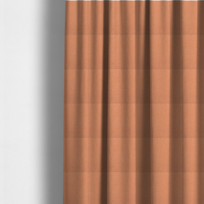 The fabric used to create these made-to-measure curtains is a vibrant apricot or orange textile with a tight diagonal twill weave. The fabric is woven with a primary saturated orange thread interspersed with fine white or cream yarns, creating a bright, textured surface with a subtle "salt and pepper" effect.