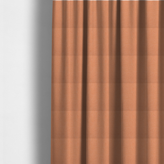 The fabric used to create these made-to-measure curtains is a vibrant apricot or orange textile with a tight diagonal twill weave. The fabric is woven with a primary saturated orange thread interspersed with fine white or cream yarns, creating a bright, textured surface with a subtle "salt and pepper" effect.