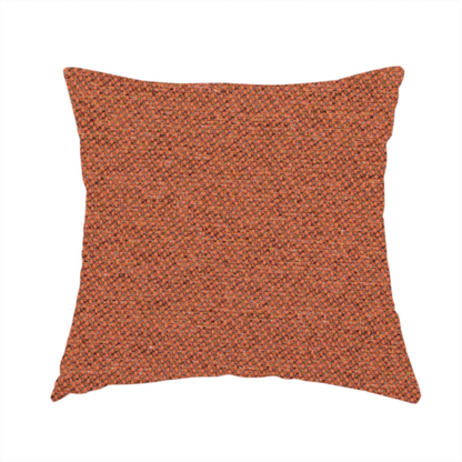 The fabric used to create this handmade cushion is a deep rust or burnt orange textile with a dense diagonal twill weave. The fabric features a rich, multi-tonal blend of saturated orange yarns interlaced with darker brown and subtle flecks of green or gold, giving it a heathered, earthy depth.