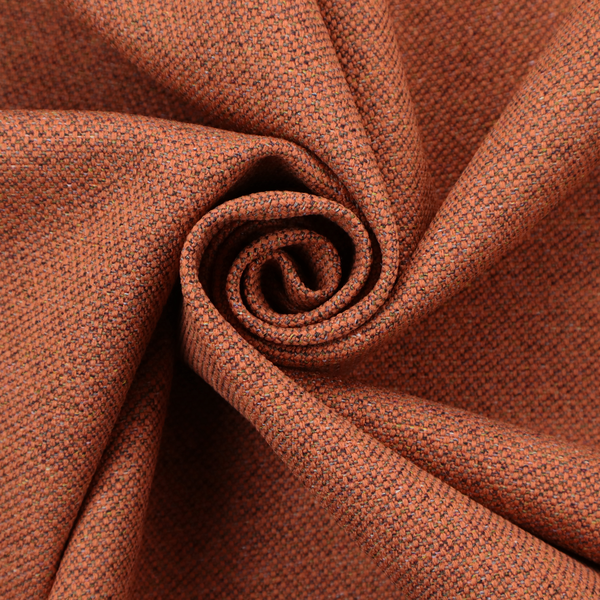 A deep rust or burnt orange textile with a dense diagonal twill weave. The fabric features a rich, multi-tonal blend of saturated orange yarns interlaced with darker brown and subtle flecks of green or gold, giving it a heathered, earthy depth.