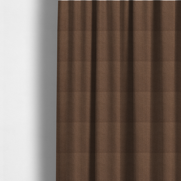 The fabric used to create these made-to-measure curtains is a dark chocolate or mocha brown textile with a tight diagonal twill weave. The fabric is woven with a deep brown base interspersed with fine, lighter threads that create a subtle shimmering or "salt and pepper" effect across the surface.