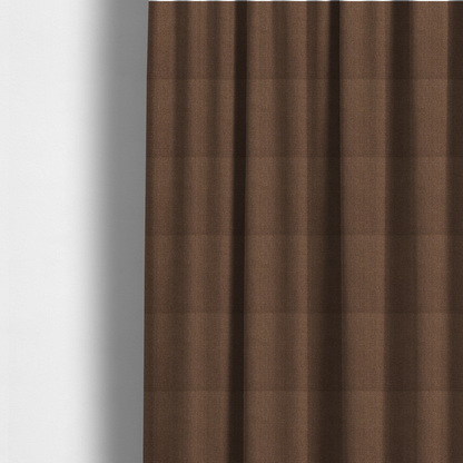 The fabric used to create these made-to-measure curtains is a dark chocolate or mocha brown textile with a tight diagonal twill weave. The fabric is woven with a deep brown base interspersed with fine, lighter threads that create a subtle shimmering or "salt and pepper" effect across the surface.