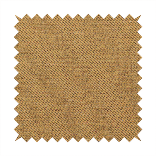 A golden mustard or ochre textile featuring a dense diagonal twill weave. The fabric is a multi-tonal blend, interlacing warm yellow-gold yarns with subtle flecks of darker brown and charcoal, creating a rich, heathered depth.