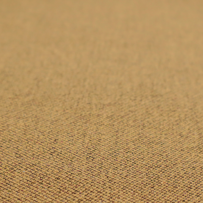 A golden mustard or ochre textile featuring a dense diagonal twill weave. The fabric is a multi-tonal blend, interlacing warm yellow-gold yarns with subtle flecks of darker brown and charcoal, creating a rich, heathered depth.