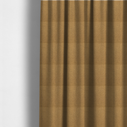 The fabric used to create these made-to-measure curtains is a golden mustard or ochre textile featuring a dense diagonal twill weave. The fabric is a multi-tonal blend, interlacing warm yellow-gold yarns with subtle flecks of darker brown and charcoal, creating a rich, heathered depth.