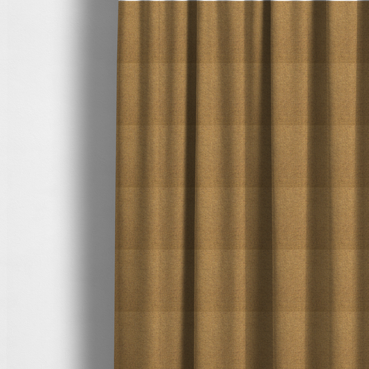 The fabric used to create these made-to-measure curtains is a golden mustard or ochre textile featuring a dense diagonal twill weave. The fabric is a multi-tonal blend, interlacing warm yellow-gold yarns with subtle flecks of darker brown and charcoal, creating a rich, heathered depth.