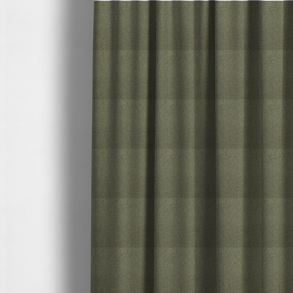 The fabric used to create these made-to-measure curtains is a olive or moss green textile featuring a dense diagonal twill weave. The fabric is a multi-tonal blend, interlacing earthy brownish-grey yarns with vibrant lime green flecks, creating a textured, heathered appearance.