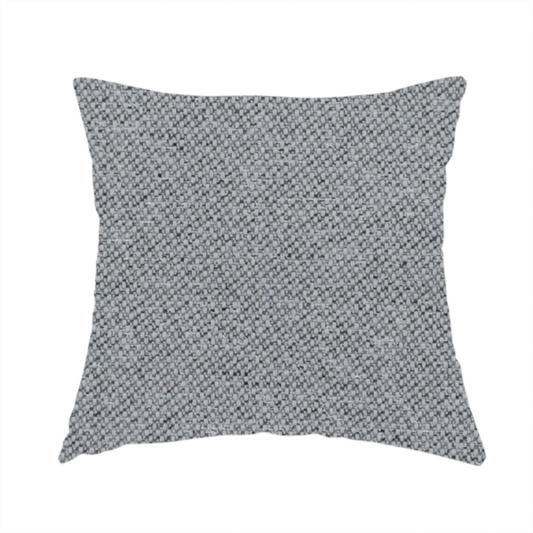 The fabric used to create this handmade cushion is a cool steel or light blue-grey textile featuring a tight diagonal twill weave. The fabric is a multi-tonal blend, interlacing medium grey yarns with pale blue and crisp white threads, creating a clean, heathered appearance.