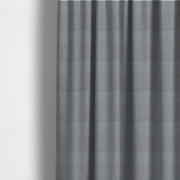 The fabric used to create these made-to-measure curtains is a cool steel or light blue-grey textile featuring a tight diagonal twill weave. The fabric is a multi-tonal blend, interlacing medium grey yarns with pale blue and crisp white threads, creating a clean, heathered appearance.