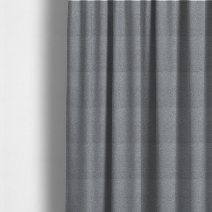 The fabric used to create these made-to-measure curtains is a cool steel or light blue-grey textile featuring a tight diagonal twill weave. The fabric is a multi-tonal blend, interlacing medium grey yarns with pale blue and crisp white threads, creating a clean, heathered appearance.