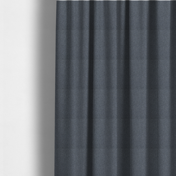 The fabric used to create these made-to-measure curtains is a seal grey textile featuring a tight diagonal twill weave. The fabric is a multi-tonal blend, interlacing deep charcoal and slate yarns with subtle flecks of lighter grey and muted blue, creating a sophisticated, heathered depth.