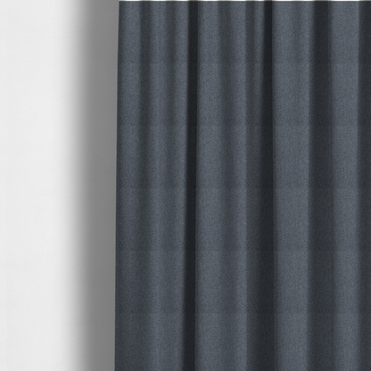 The fabric used to create these made-to-measure curtains is a seal grey textile featuring a tight diagonal twill weave. The fabric is a multi-tonal blend, interlacing deep charcoal and slate yarns with subtle flecks of lighter grey and muted blue, creating a sophisticated, heathered depth.