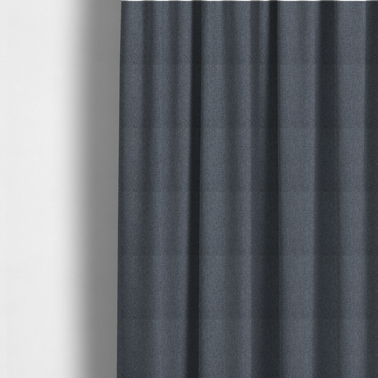 The fabric used to create these made-to-measure curtains is a seal grey textile featuring a tight diagonal twill weave. The fabric is a multi-tonal blend, interlacing deep charcoal and slate yarns with subtle flecks of lighter grey and muted blue, creating a sophisticated, heathered depth.