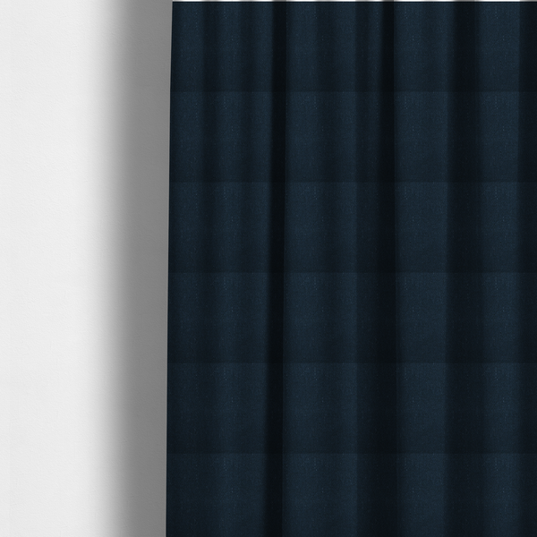 The fabric used to create these made-to-measure curtains is a deep navy or midnight blue textile featuring a tight diagonal twill weave. The fabric is woven primarily with saturated dark blue yarns, interspersed with very fine, sparse white or light grey flecks that create a subtle starlight effect.