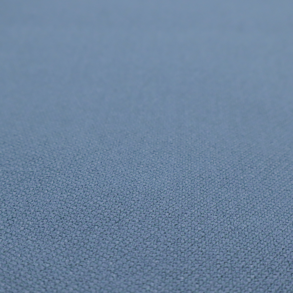 A medium denim or cornflower blue textile featuring a tight diagonal twill weave. The fabric is woven with a blend of soft blue and muted grey-blue yarns, creating a calm, uniform colour profile with subtle tonal depth.