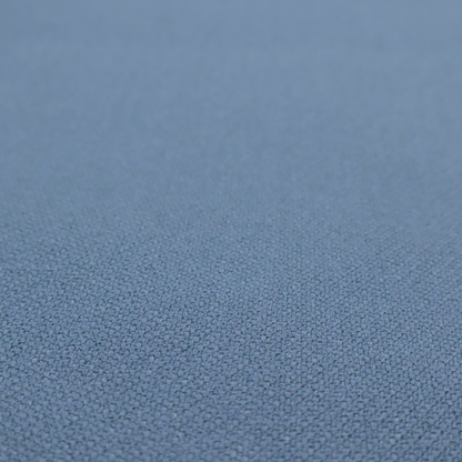 A medium denim or cornflower blue textile featuring a tight diagonal twill weave. The fabric is woven with a blend of soft blue and muted grey-blue yarns, creating a calm, uniform colour profile with subtle tonal depth.