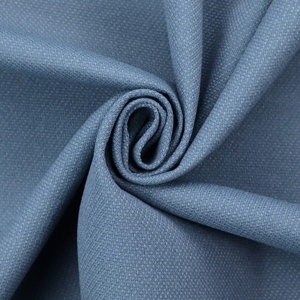 A medium denim or cornflower blue textile featuring a tight diagonal twill weave. The fabric is woven with a blend of soft blue and muted grey-blue yarns, creating a calm, uniform colour profile with subtle tonal depth.