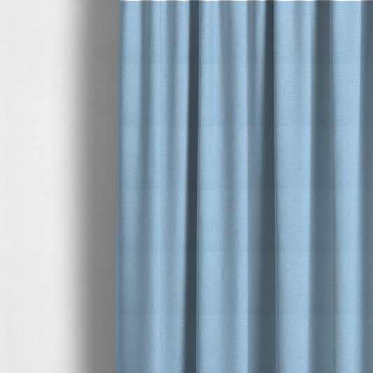 The fabric used to create these made-to-measure curtains is a sky blue or powder blue textile featuring a tight diagonal twill weave. The fabric is woven with bright, airy blue yarns interlaced with crisp white threads, creating a fresh, luminous, and slightly heathered appearance.