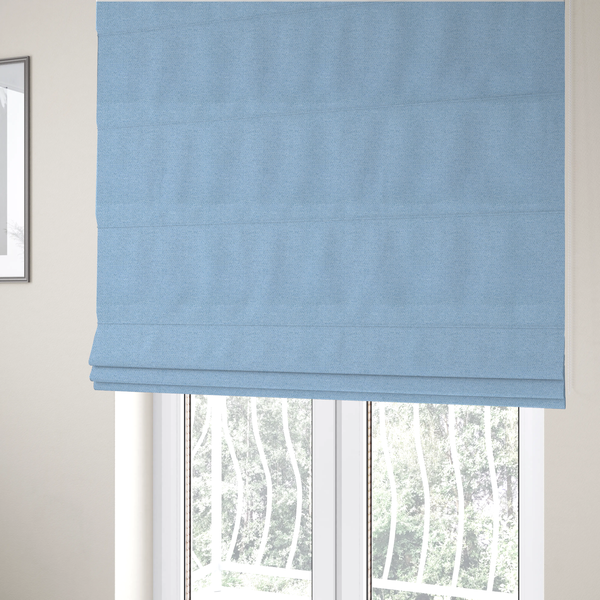The fabric used to create these Roman blinds is a  sky blue or powder blue textile featuring a tight diagonal twill weave. The fabric is woven with bright, airy blue yarns interlaced with crisp white threads, creating a fresh, luminous, and slightly heathered appearance.