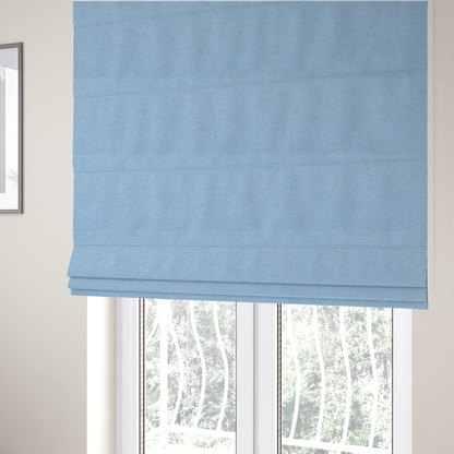 The fabric used to create these Roman blinds is a  sky blue or powder blue textile featuring a tight diagonal twill weave. The fabric is woven with bright, airy blue yarns interlaced with crisp white threads, creating a fresh, luminous, and slightly heathered appearance.