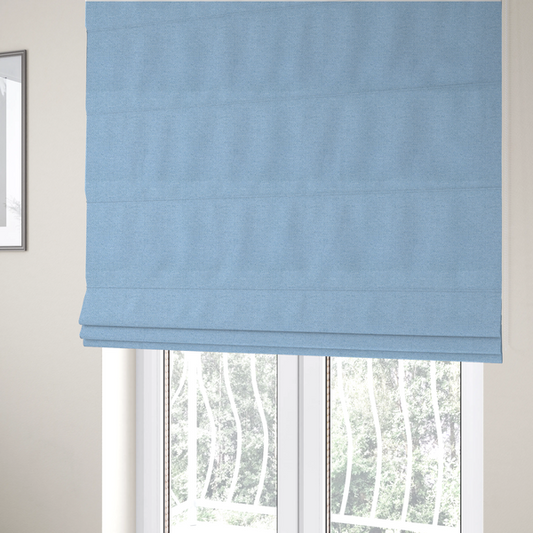 The fabric used to create these Roman blinds is a  sky blue or powder blue textile featuring a tight diagonal twill weave. The fabric is woven with bright, airy blue yarns interlaced with crisp white threads, creating a fresh, luminous, and slightly heathered appearance.