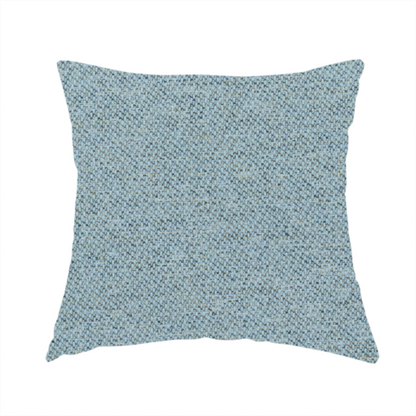 The fabric used to create this handmade cushion is a dusty aqua or pale teal textile featuring a tight diagonal twill weave. The fabric is a multi-tonal blend, interlacing soft blue-green yarns with subtle flecks of grey and pale gold, creating a sophisticated, heathered depth.