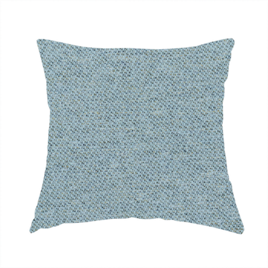 The fabric used to create this handmade cushion is a dusty aqua or pale teal textile featuring a tight diagonal twill weave. The fabric is a multi-tonal blend, interlacing soft blue-green yarns with subtle flecks of grey and pale gold, creating a sophisticated, heathered depth.