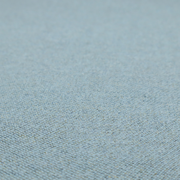 A dusty aqua or pale teal textile featuring a tight diagonal twill weave. The fabric is a multi-tonal blend, interlacing soft blue-green yarns with subtle flecks of grey and pale gold, creating a sophisticated, heathered depth.