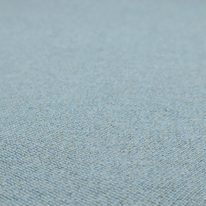 A dusty aqua or pale teal textile featuring a tight diagonal twill weave. The fabric is a multi-tonal blend, interlacing soft blue-green yarns with subtle flecks of grey and pale gold, creating a sophisticated, heathered depth.