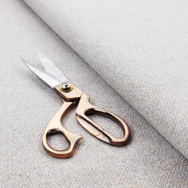 a light oatmeal or pearl grey textile featuring a tight diagonal twill weave. The fabric is a multi-tonal blend, interlacing crisp white and pale grey yarns with subtle flecks of soft gold and charcoal, creating a luminous, heathered appearance.