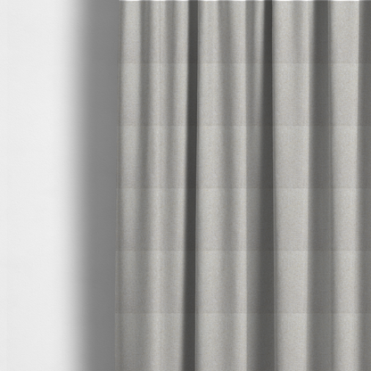 The fabric used to create these made-to-measure curtains is a light oatmeal or pearl grey textile featuring a tight diagonal twill weave. The fabric is a multi-tonal blend, interlacing crisp white and pale grey yarns with subtle flecks of soft gold and charcoal, creating a luminous, heathered appearance.