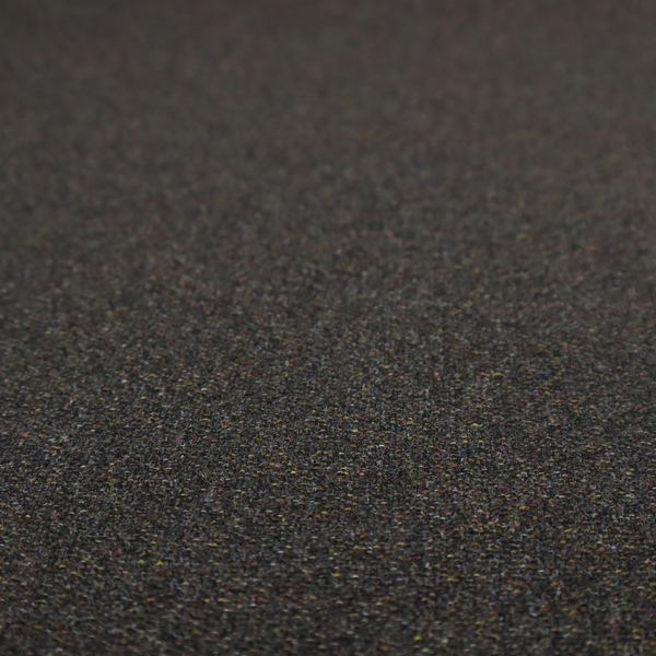 A near-black charcoal base heavily flecked with multi-coloured yarns in gold, rust, and grey.