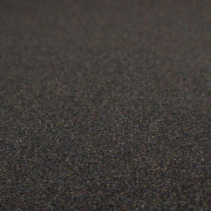 A near-black charcoal base heavily flecked with multi-coloured yarns in gold, rust, and grey.