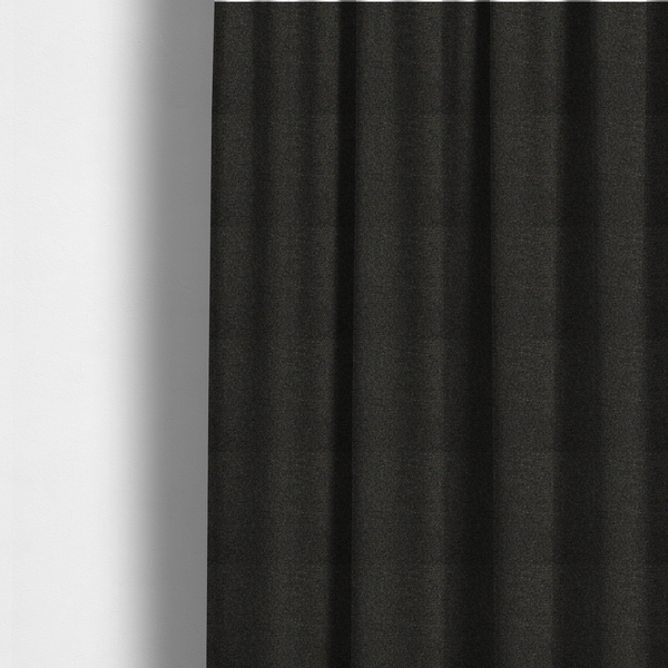 the fabric used to create these made-to-measure curtains is a near-black charcoal base heavily flecked with multi-coloured yarns in gold, rust, and grey.