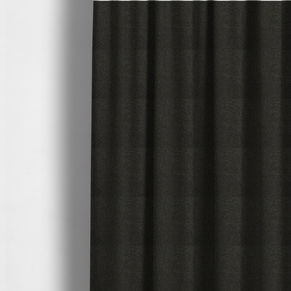 the fabric used to create these made-to-measure curtains is a near-black charcoal base heavily flecked with multi-coloured yarns in gold, rust, and grey.