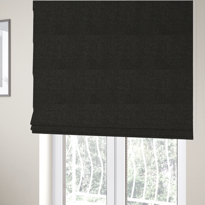The fabric used to create these Roman blinds is a near-black charcoal base heavily flecked with multi-coloured yarns in gold, rust, and grey.
