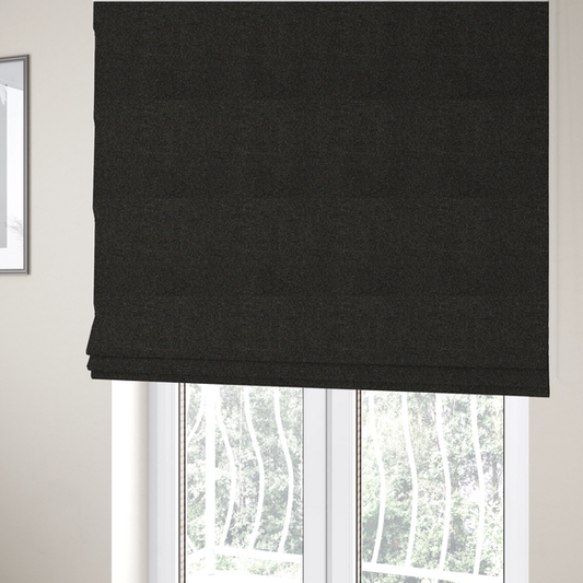 The fabric used to create these Roman blinds is a near-black charcoal base heavily flecked with multi-coloured yarns in gold, rust, and grey.