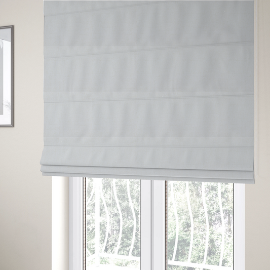 The fabric used to create these Roman blinds is a light-coloured, off-white fabric with a fine, textured weave.