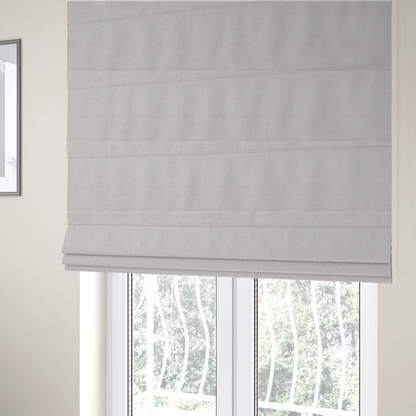 The fabric used to create these Roman blinds is a light beige upholstery fabric with a fine, textured weave.