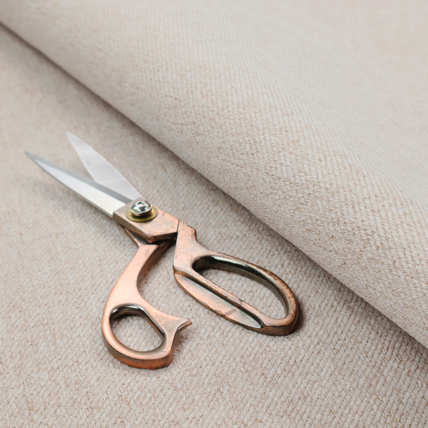 A light beige and tan upholstery fabric with a fine, multi-tonal textured weave.