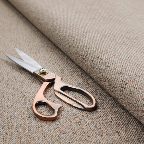 A warm grey and brown upholstery fabric with a dense, diagonal textured weave.