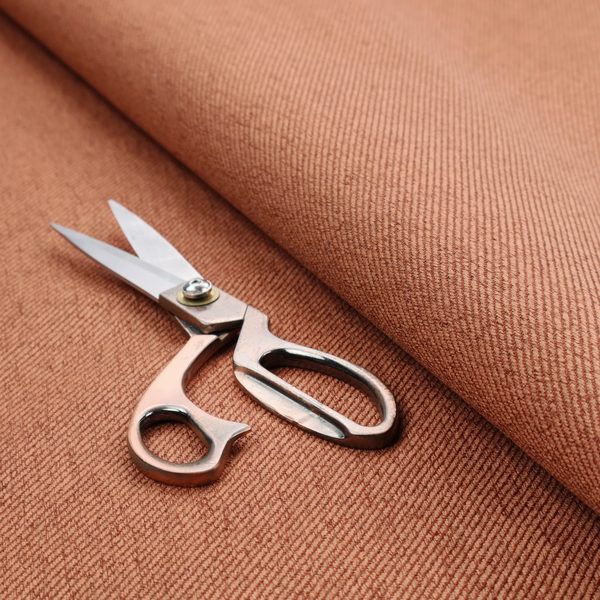 A rust-orange upholstery fabric with a dense, diagonal textured weave.