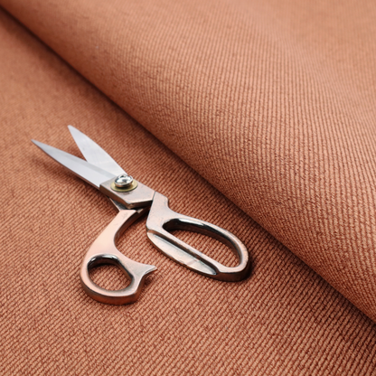 A rust-orange upholstery fabric with a dense, diagonal textured weave.