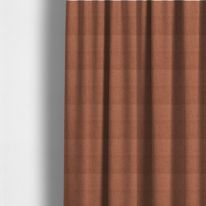 The fabric used to create these made-to-measure curtains is a rust-orange upholstery fabric with a dense, diagonal textured weave.