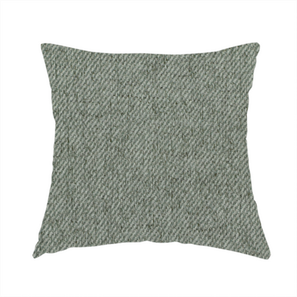 The fabric used to create this handmade cushion is a sage green upholstery fabric with a dense, diagonal textured weave.