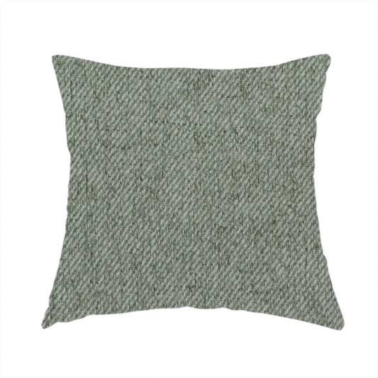 The fabric used to create this handmade cushion is a sage green upholstery fabric with a dense, diagonal textured weave.