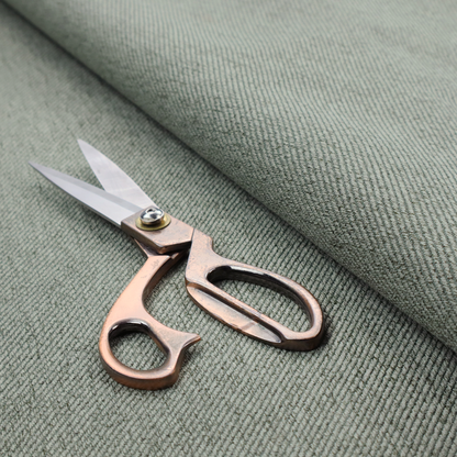 A sage green upholstery fabric with a dense, diagonal textured weave.
