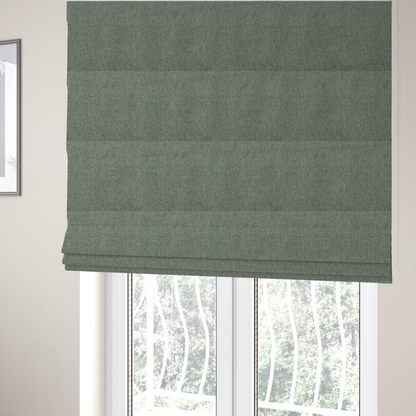 The fabric used to create these Roman blinds is a sage green upholstery fabric with a dense, diagonal textured weave.